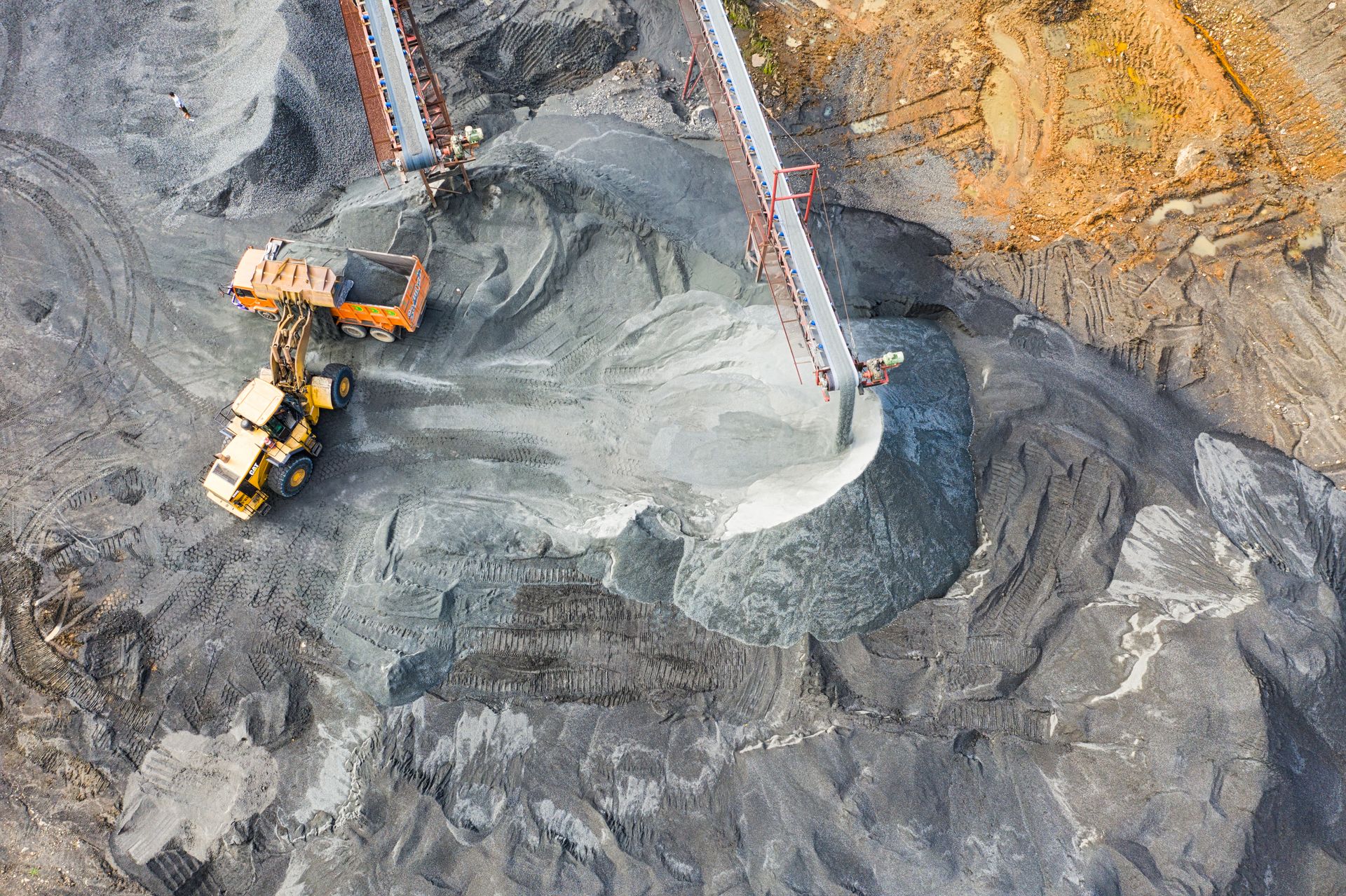 Aerial view of a working mineral plant with loaders and conveyors